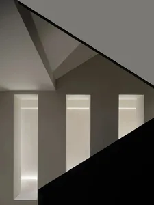 A minimalist design with concrete walls and a black floor.