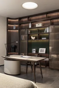 A modern office space featuring a wooden density board desk, a bookshelf with built-in lighting, and a comfortable chair.