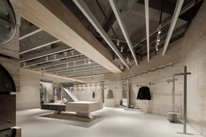 A modern retail shop interior with timber elements, featuring clothing racks and a display area.