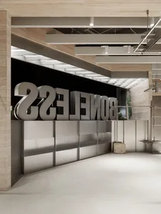 Modern, minimalist office space with large metallic letters spelling 'BONELLES' against a black background, complemented by c