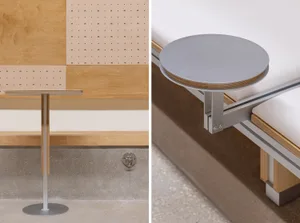 A minimalist table with a metal base and round, grey tabletop.