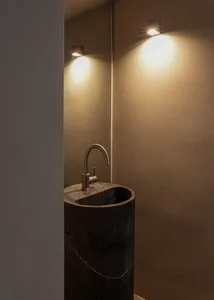 Modern minimalist bathroom with a sleek, black marble sink and metallic fixtures.