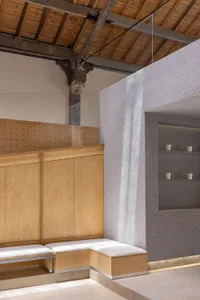 Retro coffee shop interior with wooden cabinets, concrete floors, and industrial lighting.