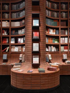 Bookshelf with brick columns and walls displaying books in a library setting