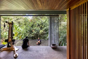 A minimalist residential space featuring wooden flooring and a workout machine with an outdoor view.