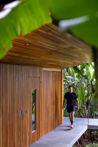 A modern landscape with wooden features, including a pathway and a structure with a wooden ceiling and walls.