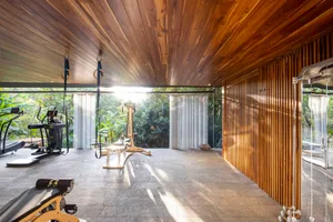 A modern minimalist gym with wooden elements and exercise equipment.