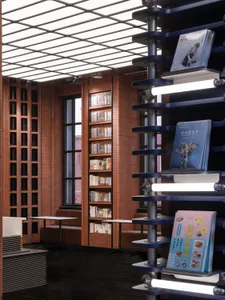 Industrially designed library with exposed brick walls, metal shelves, and glass windows.
