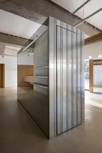A modern retail storefront with a metallic, textured wall