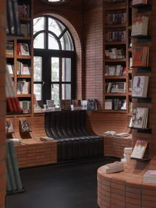 A cozy bookstore with brick walls, arched windows, and a comfortable seating area filled with books.