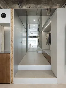 Modern clothing retail space featuring glass storefront and minimalist design.