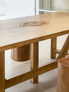 A minimalist wooden table featuring a carved Dickies logo, suitable for industrial or rustic interior design.