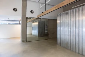 A minimalist showroom with metallic walls and polished concrete floor.