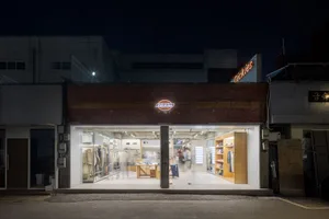 現代零售店面採用玻璃磚與混凝土材質，並以溫暖燈光照亮。
