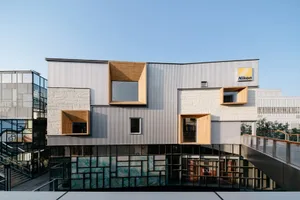 A modern storefront with metal cladding and wood accents.