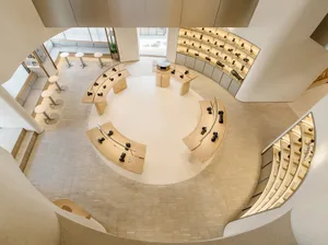 A modern photography studio featuring curved wooden display tables and illuminated lighting.
