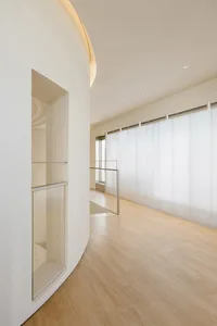 Modern minimalist office space with a glass wall, featuring clean lines and a sleek design.