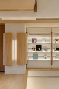 A modern bookstore featuring wooden shelves, plaster walls, and glass displays