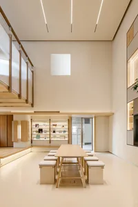A minimalist modern library with wooden shelving and a large window