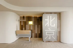 A modern office interior featuring minimalist design elements such as wood, metal, and textured tiles.