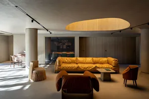 Modern minimalist living room with concrete flooring and minimalist furniture.