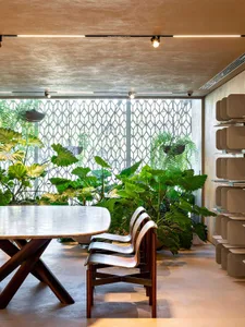 A modern restaurant interior with wooden furniture and concrete flooring and walls.