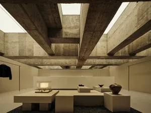 Modern minimalist interior with concrete walls and floors, featuring simple geometric furniture and natural lighting.