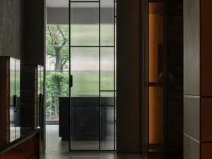 簡約室內空間，玻璃門外可見花園景觀。