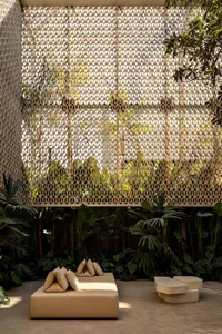 A minimalist outdoor seating area with concrete furniture and natural fiber accents.