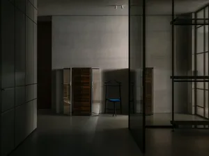 Modern minimalist interior with metallic furniture, focusing on a tall wardrobe unit.