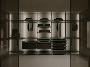 Modern closet with glass doors and steel shelves, featuring sleek design and elegant storage solutions.