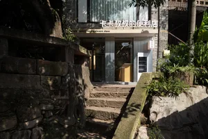 Modern storefront with concrete walls and glass doors.