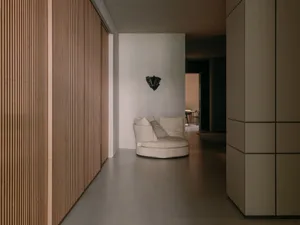 A modern interior corridor featuring wood-paneled walls and concrete flooring.