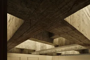 An interior space with modern design, featuring concrete beams and walls.