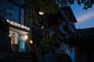 Modern retail storefront with illuminated signage and concrete and glass materials at dusk.