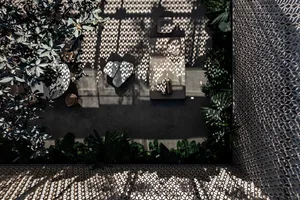 Modern minimalist garden featuring concrete walls with intricate patterns