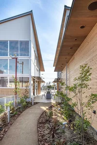 A minimalist commercial building with wooden accents, glass windows, and concrete elements.