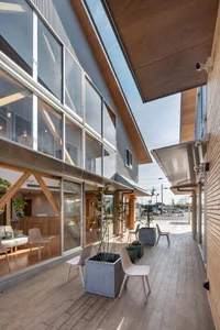 A modern exterior with glass walls and a wooden roof.