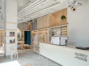 Modern coffee shop interior featuring wooden and concrete materials with a minimalist design aesthetic.