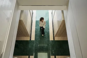 A corridor with white walls and marble floors