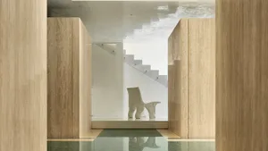 A modern marble entryway with sleek, minimalist design elements and a sculptural white chair.