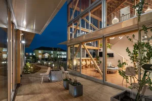 Modern residential interior with wooden floors, glass walls, and minimalist furniture.