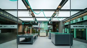 A modern retail storefront featuring a green-themed interior with sleek, minimalist furniture and lighting.