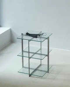 A modern, industrial-style glass shelf system with three tiers