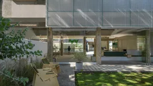 Minimalist interior design featuring glass walls and wooden furniture in a cafeteria setting.