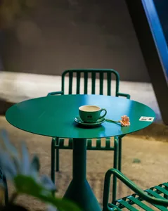 A minimalist green metallic coffee shop with a green cup of coffee.
