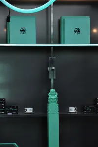 A modern bookstore display featuring turquoise book covers and white coffee cups.
