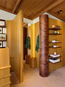 Modern clothing shop with wooden walls and clothing racks.