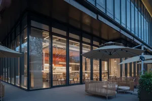 A modern coffee shop with glass walls and steel accents.
