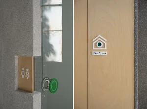 A simple, modern door handle installed on a wooden door.
